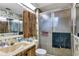 Bathroom features a sliding glass door shower, wood cabinet, floral wallpaper, and marble sink at 4282 Alice St, Edgewater, FL 32141