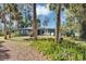 Charming single-story home with a lush lawn, surrounded by palm trees and other mature trees at 4282 Alice St, Edgewater, FL 32141