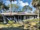 A charming exterior with a screened-in porch and mature trees provides a serene and inviting curb appeal at 4282 Alice St, Edgewater, FL 32141