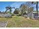 Large backyard featuring a well-maintained lawn, storage shed, and white picket fence at 435 N Oak Ave, Orange City, FL 32763