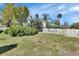 Expansive backyard with green lawn, white picket fence, mature trees, and a storage shed at 435 N Oak Ave, Orange City, FL 32763