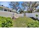 Spacious fenced backyard with lush lawn, patio, and charming white picket fence with gate at 435 N Oak Ave, Orange City, FL 32763