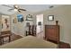 Bedroom featuring wood floors, a dresser, ceiling fan, and a view to the kitchenette at 435 N Oak Ave, Orange City, FL 32763