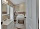 Laundry room area features a sink, washer, dryer, cabinets, and tile floor at 435 N Oak Ave, Orange City, FL 32763