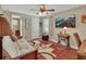 Inviting living room with a futon couch, hardwood floors, ceiling fan, and an antique sewing table at 435 N Oak Ave, Orange City, FL 32763
