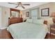 Comfortable main bedroom with a ceiling fan, soft lighting, and a wooden dresser with mirror at 435 N Oak Ave, Orange City, FL 32763