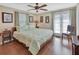 Spacious main bedroom featuring a ceiling fan, wood floors, and a private exit to the outdoor area at 435 N Oak Ave, Orange City, FL 32763