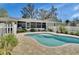 Lovely backyard with a pristine pool, brick patio, screened-in porch, and well-manicured landscaping at 435 N Oak Ave, Orange City, FL 32763