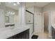 Bathroom features a double sink vanity with black cabinets, quartz counters, and a glass enclosed shower at 471 Portico Ct, Oviedo, FL 32765
