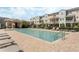 Community pool featuring lounge chairs, tables, umbrellas and nearby condo buildings at 471 Portico Ct, Oviedo, FL 32765