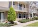 Two-story townhome with a covered porch, balcony, and well-maintained front yard landscaping at 471 Portico Ct, Oviedo, FL 32765