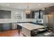 Modern kitchen features dark wood cabinets, stainless appliances, and large quartz island at 471 Portico Ct, Oviedo, FL 32765
