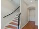 Staircase with hardwood treads, black iron spindles and stained handrail offers charm and elegance at 471 Portico Ct, Oviedo, FL 32765