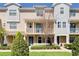 Charming multi-level townhome featuring a covered porch, balcony, neutral siding, and lush landscaping at 471 Portico Ct, Oviedo, FL 32765