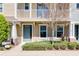 Close-up of a townhome with a gray front door, beige exterior, and tidy, green landscaping at 471 Portico Ct, Oviedo, FL 32765