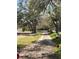 Gravel driveway flanked by mature trees and green grass at 485 Dickson Ave, Osteen, FL 32764