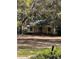 An exterior of a quaint cottage-style home with mature trees providing shade at 485 Dickson Ave, Osteen, FL 32764