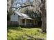 Single-story home with a covered porch, surrounded by mature trees and grass at 485 Dickson Ave, Osteen, FL 32764
