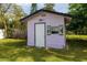 Exterior view of a shed featuring unique tropical-themed decorations on a window and a white door at 509 Mcintosh Rd, Ormond Beach, FL 32174