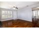 Bright living room featuring hardwood floors, a ceiling fan, and large windows with plantation shutters at 509 Mcintosh Rd, Ormond Beach, FL 32174