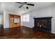 Cozy living room featuring hardwood floors, a ceiling fan, fireplace and a built in cabinet at 509 Mcintosh Rd, Ormond Beach, FL 32174