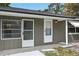 Welcoming front entrance with a white door, glass windows, and painted grey brick at 512 Power Rd, Sanford, FL 32771