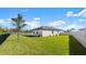 Expansive backyard featuring a well-maintained lawn, privacy fence, and modern home exterior at 615 Tortuga Ct, New Smyrna Beach, FL 32168