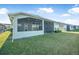 A serene view of the home's screened-in lanai and meticulously maintained lawn, offering a perfect outdoor retreat at 6263 W Fallsgrove Ln, Port Orange, FL 32128