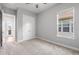 Carpeted bedroom featuring ceiling fan, closet, paneled door, and large window offering ample storage at 6263 W Fallsgrove Ln, Port Orange, FL 32128