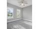 A bright, carpeted bedroom with two windows and a ceiling fan offers ample natural light and comfort at 6263 W Fallsgrove Ln, Port Orange, FL 32128