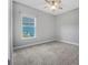 Bedroom with neutral paint, carpet, ceiling fan, and window offers a serene retreat within the home at 6263 W Fallsgrove Ln, Port Orange, FL 32128