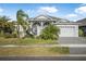 Charming single-story home with a well-manicured lawn and a paver driveway, surrounded by lush landscaping at 6263 W Fallsgrove Ln, Port Orange, FL 32128