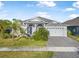 Inviting single-story home featuring a two-car garage and well-kept landscaping, creating an attractive facade at 6263 W Fallsgrove Ln, Port Orange, FL 32128