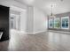 Bright open-plan living space with wood-look tile floors, complemented by a modern chandelier at 6263 W Fallsgrove Ln, Port Orange, FL 32128