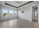 Main bedroom with lake view, three large windows, and ensuite bathroom at 6263 W Fallsgrove Ln, Port Orange, FL 32128