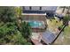 An aerial view of the backyard pool, shed, and surrounding greenery at 707 Leeward Dr, Deltona, FL 32738