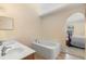Bathroom with double sinks, soaking tub, and an arched doorway leading to the bedroom at 707 Leeward Dr, Deltona, FL 32738