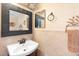 A powder room features a decorative mirror and a vanity with a pedestal sink at 707 Leeward Dr, Deltona, FL 32738