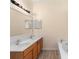 Bright bathroom featuring double sinks, wood cabinets, mirrors, and a soaking tub at 707 Leeward Dr, Deltona, FL 32738