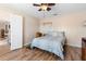 A bedroom featuring wood-look tile, a ceiling fan, a bed and an open doorway at 707 Leeward Dr, Deltona, FL 32738