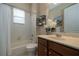 Bright bathroom featuring tub-shower combo, tile surround, single sink vanity with solid surface counter at 903 Victoria Hills S Dr, Deland, FL 32724