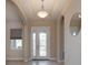 Bright foyer showcasing a decorative glass front door, arched doorways and a stylish light fixture at 903 Victoria Hills S Dr, Deland, FL 32724