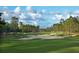 Scenic golf course view featuring lush green fairways and sand traps under a partly cloudy sky at 903 Victoria Hills S Dr, Deland, FL 32724