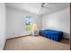Bright bedroom featuring a ceiling fan, plush carpet, and a sunny window view at 951 Lovington Dr, Deltona, FL 32738