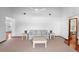 Bright living room featuring neutral carpet, white walls, ceiling fan, and comfortable seating arrangement at 951 Lovington Dr, Deltona, FL 32738