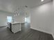 Bright open-concept living area with gray flooring, kitchen island, and stainless steel appliances, with great natural light at 951 Redwood St, Daytona Beach, FL 32117
