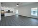 Open concept living space with gray flooring, large windows, and a ceiling fan, adjacent to the kitchen at 951 Redwood St, Daytona Beach, FL 32117