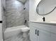 Bathroom featuring modern fixtures, including a tub, shower, toilet, and vanity with a round mirror at 955 Redwood St, Daytona Beach, FL 32117
