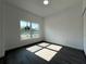 Sunny bedroom with a large window, gray floors and neutral walls at 955 Redwood St, Daytona Beach, FL 32117