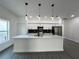 Stylish kitchen with white cabinetry, quartz countertops, stainless steel appliances, and decorative pendant lights at 955 Redwood St, Daytona Beach, FL 32117